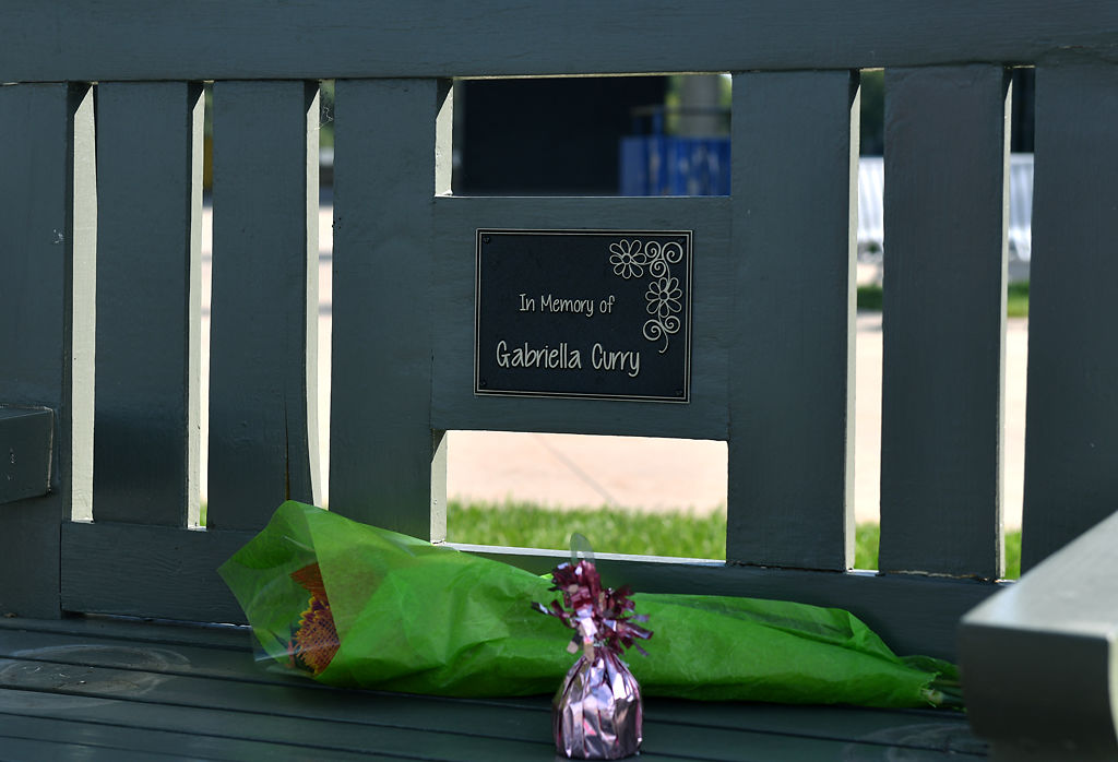 Flowers and a balloon weight sit on Gabriella Curry's memorial bench Friday at Battle High School in Columbia.